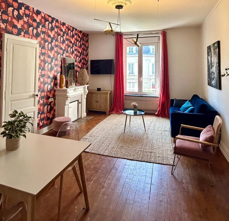 un salon avec un canapé bleu et une table dans l'établissement LE BOTANICA Bel appartement situé à 5 min de la gare d'Angers, à Angers