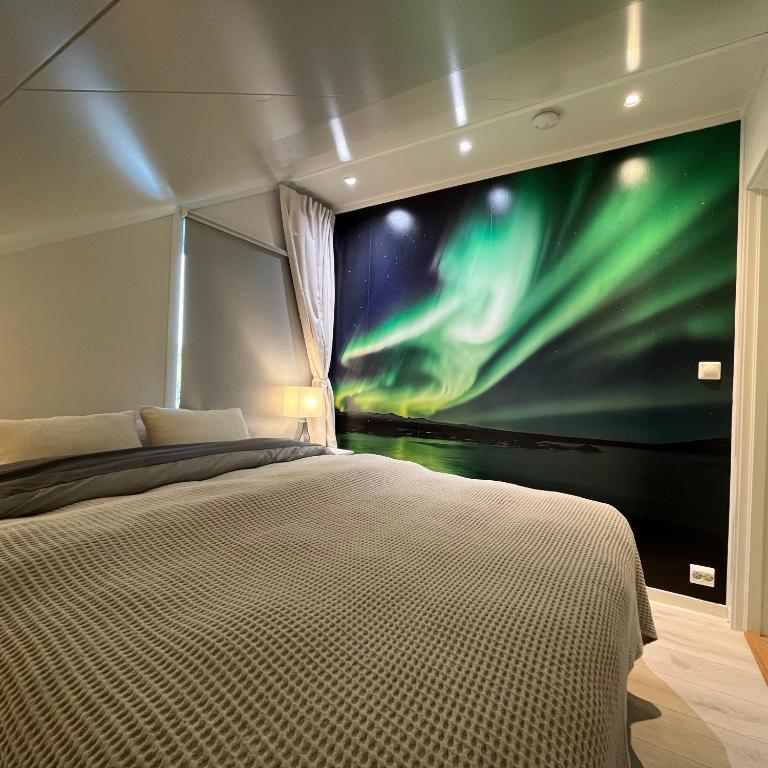 a bedroom with a large poster of the northern lights at Leilighet i Stamsund, Lofoten in Rishaugen