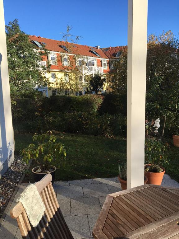 a bench on a porch with a house in the background at Residenz Strandkrone 03 in Kühlungsborn