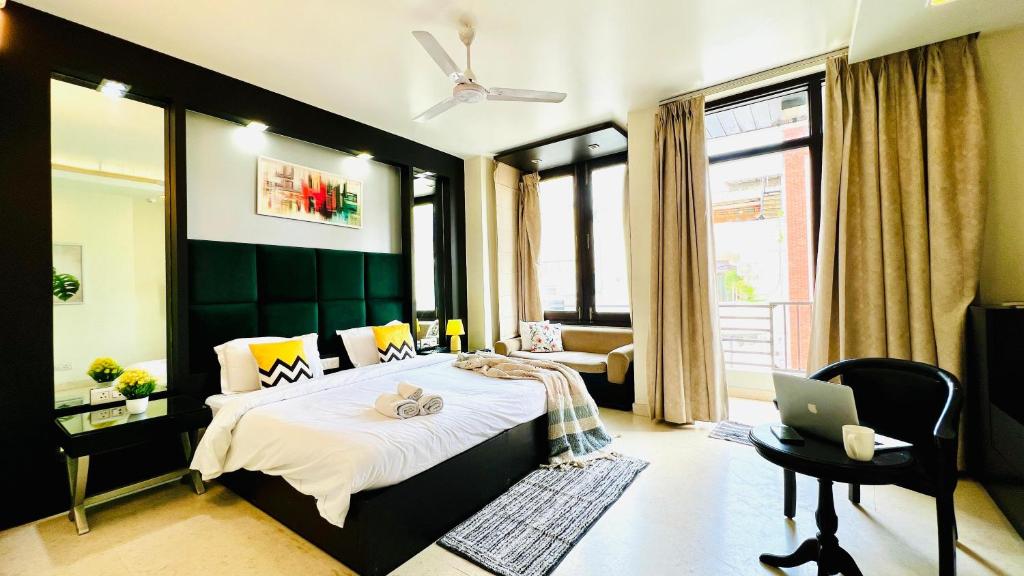 a bedroom with a bed and a laptop on it at BluO Studio - M Block Mkt Greater Kailash in New Delhi