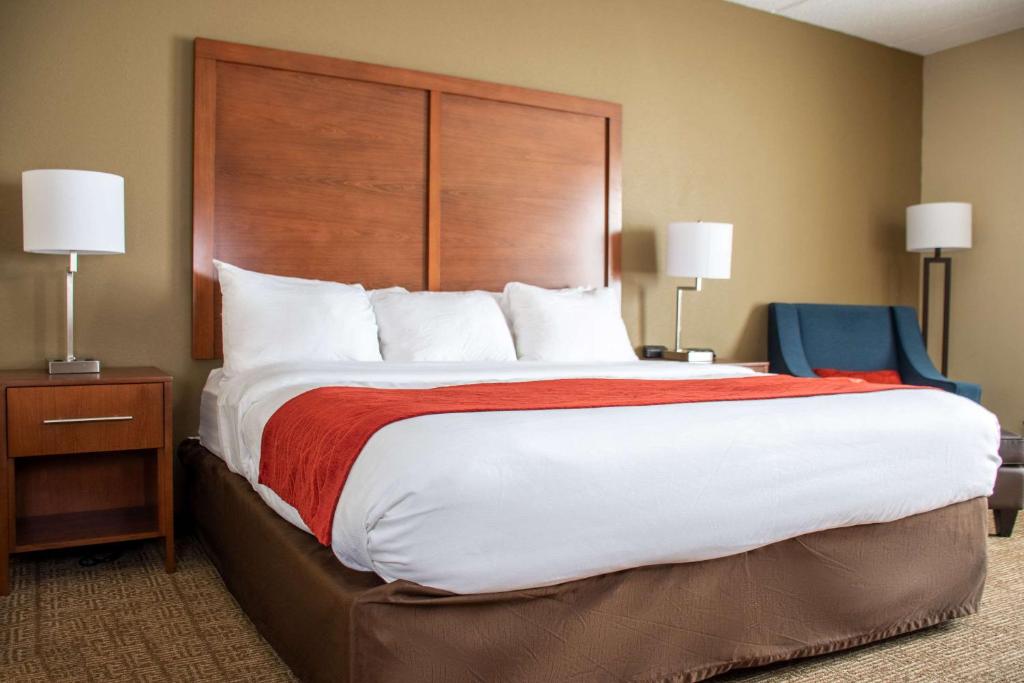 a bedroom with a large bed with a wooden headboard at Comfort Inn in Dickson