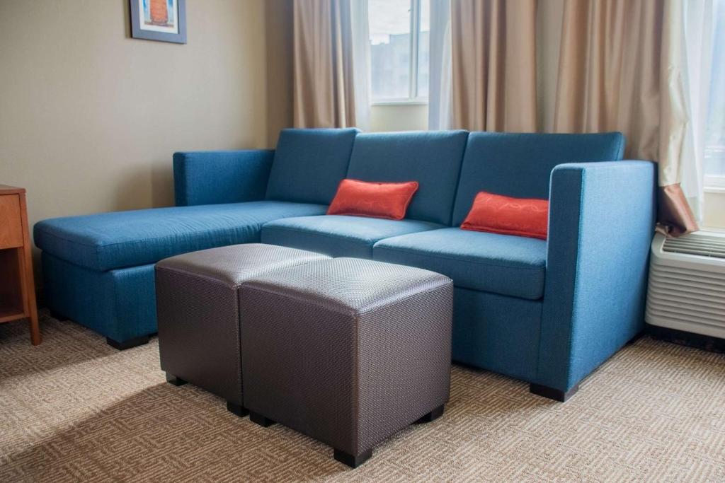a blue couch with two red pillows in a room at Comfort Inn in Dickson