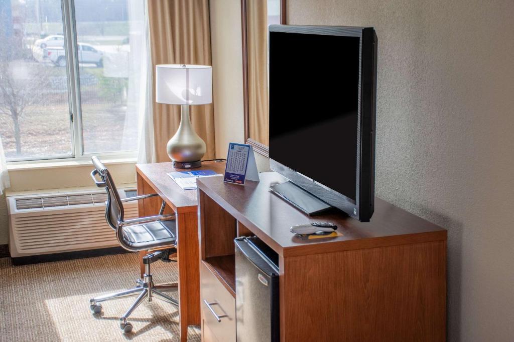 a room with a desk with a tv and a chair at Comfort Inn in Dickson