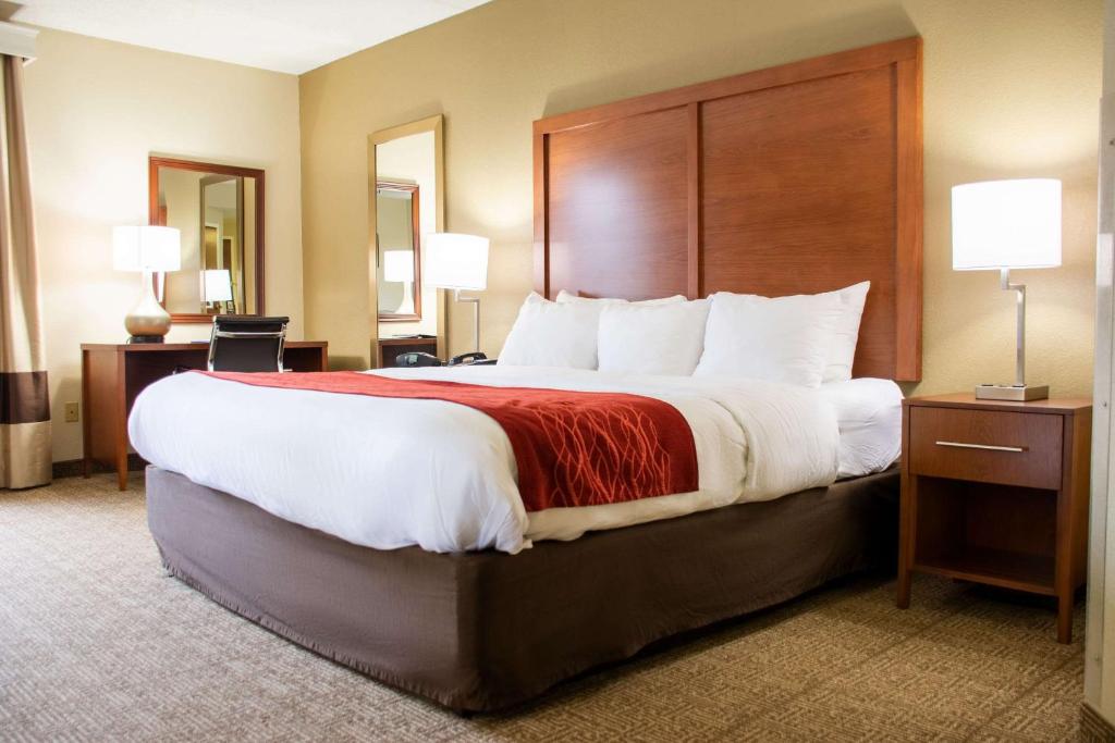 a hotel room with a large bed with a red blanket at Comfort Inn in Dickson