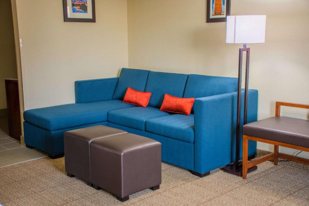 a blue couch with two red pillows in a room at Comfort Inn in Dickson