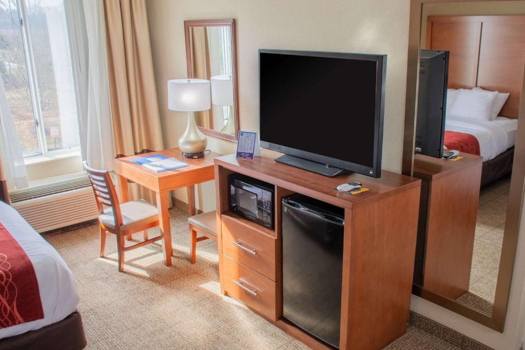 a hotel room with a television and a bed at Comfort Inn in Dickson