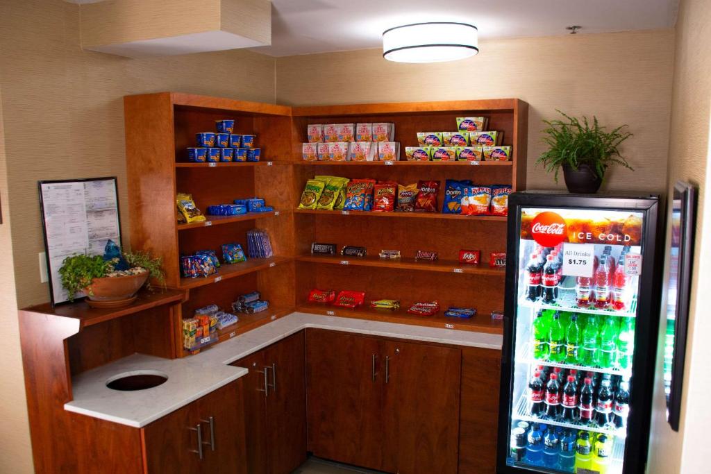 a kitchen with a refrigerator and shelves with drinks at Comfort Inn in Dickson