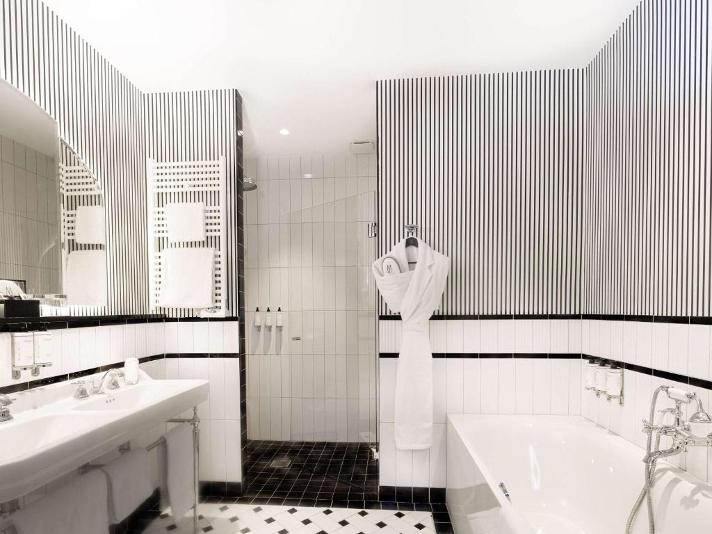 a bathroom with a tub and two sinks and a bath tub at The 1932 Hotel & Spa Cap d'Antibes - MGallery Collection in Juan-les-Pins