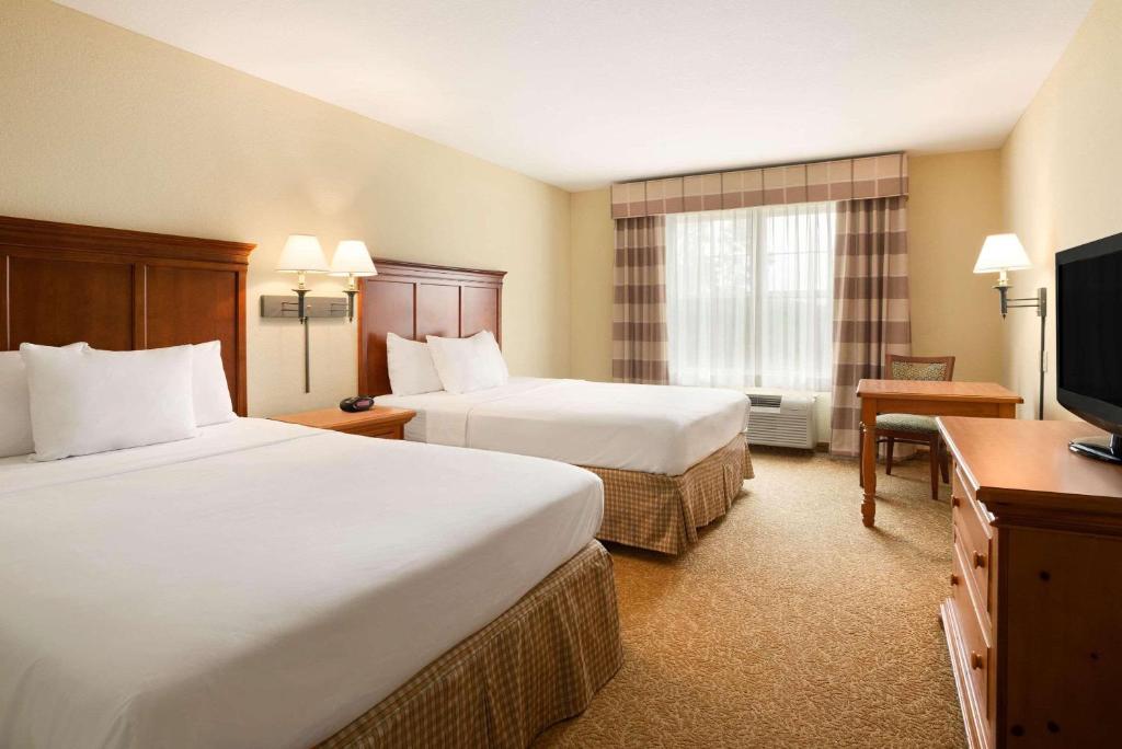 a hotel room with two beds and a flat screen tv at Country Inn & Suites by Radisson, Beckley, WV in Beckley