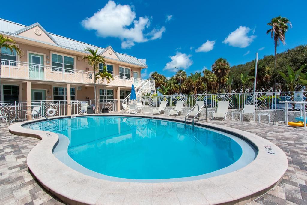 una piscina con sillas y una casa en Clearwater Beach Suites 204, en Clearwater Beach