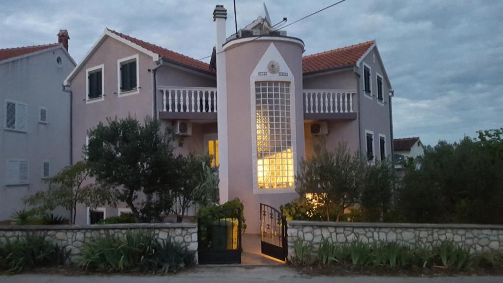 a pink house with a gate in front of it at Villa Sunce in Jezera