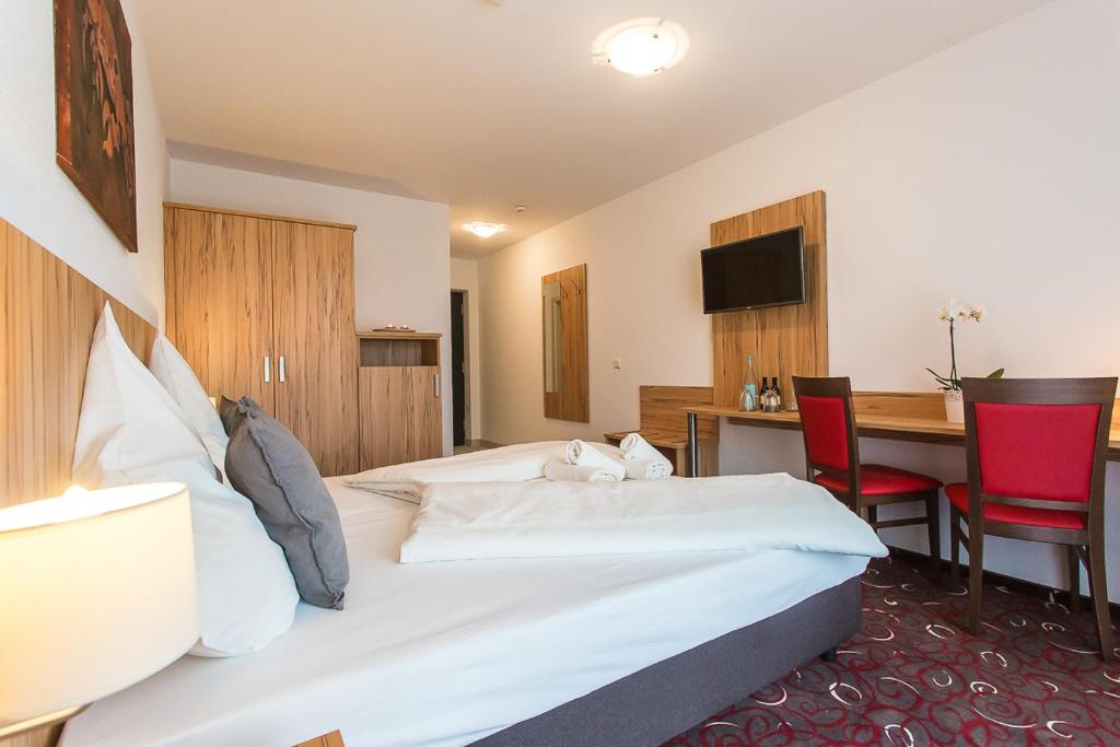 a hotel room with a bed and a table and chairs at Schäfer Boardinghouse in Gröbenzell