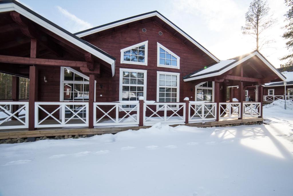 a log cabin with snow in front of it at Levi Holidays in Levi