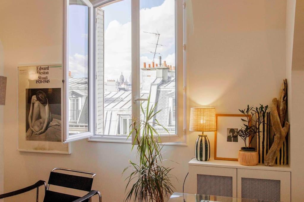 Cette chambre dispose d'une fenêtre avec des plantes et une chaise. dans l'établissement 3 pièces lumineux paris Montmartre, à Paris