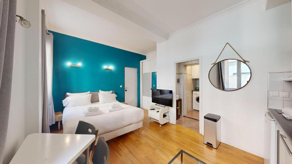 - une chambre avec un lit blanc et un mur bleu dans l'établissement Bluestay 235 - Superbe appartement à Paris, à Paris
