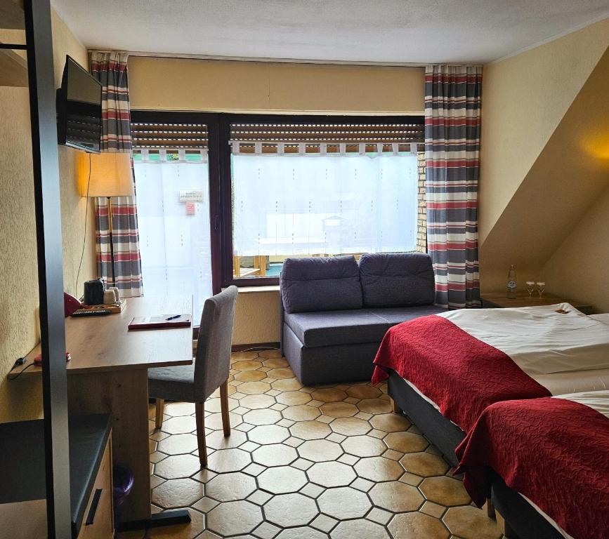 a hotel room with a bed and a desk and a couch at Haus Scheuten Hotel in Duisburg