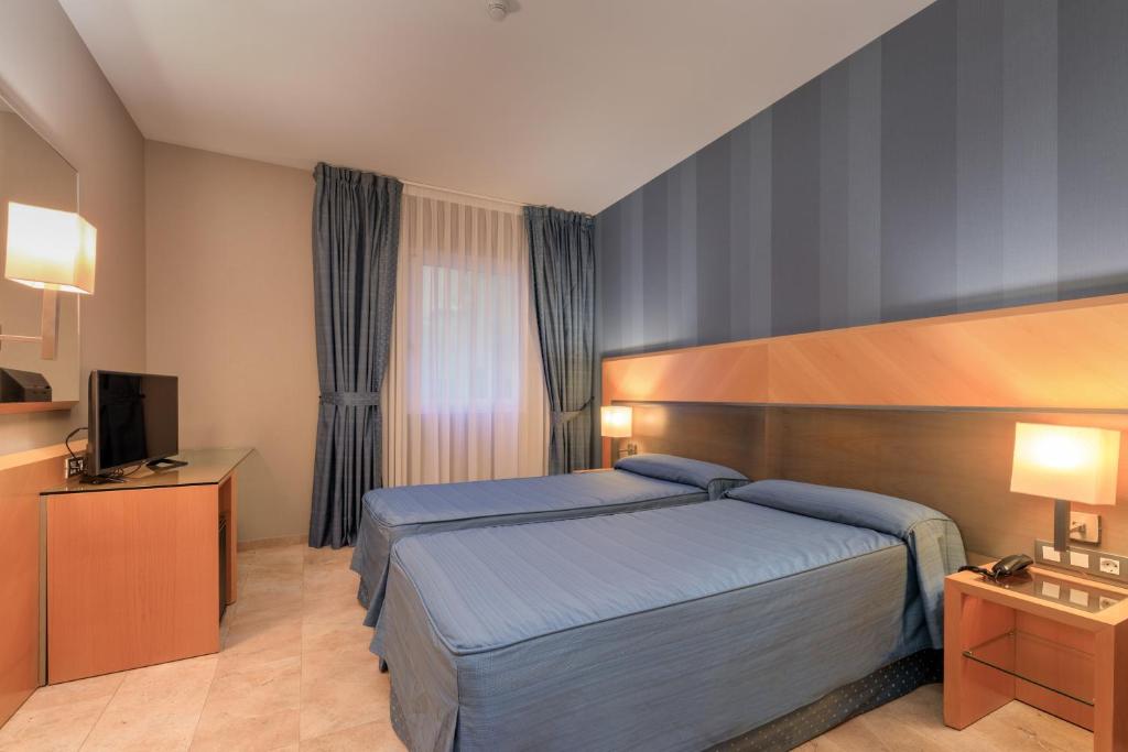 a hotel room with a bed and a television at Hotel del Mar in Barcelona