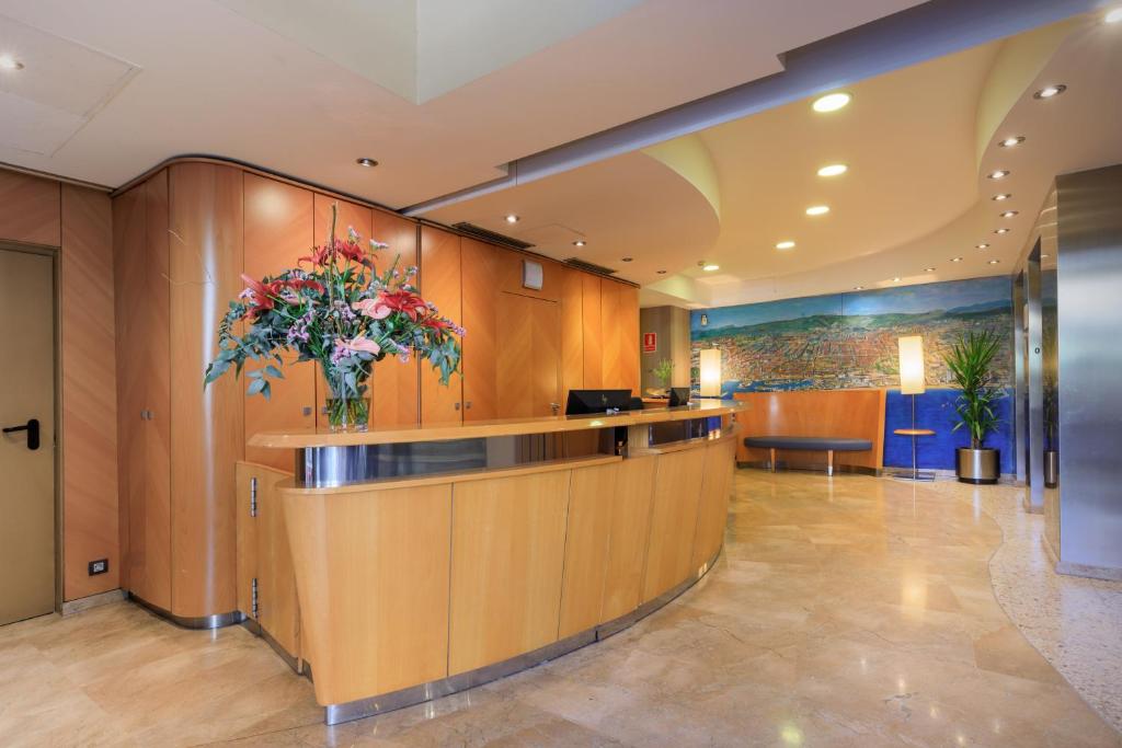 a lobby with a vase of flowers on a counter at Hotel del Mar in Barcelona