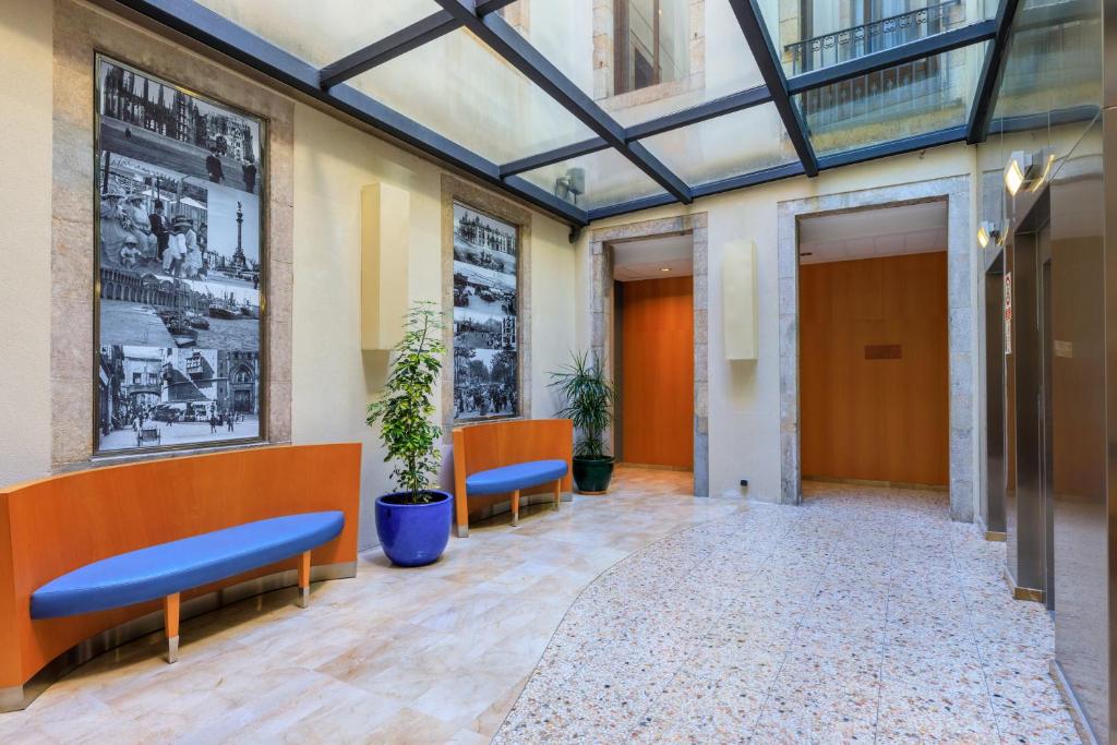 an empty lobby with two blue benches in a building at Hotel del Mar in Barcelona