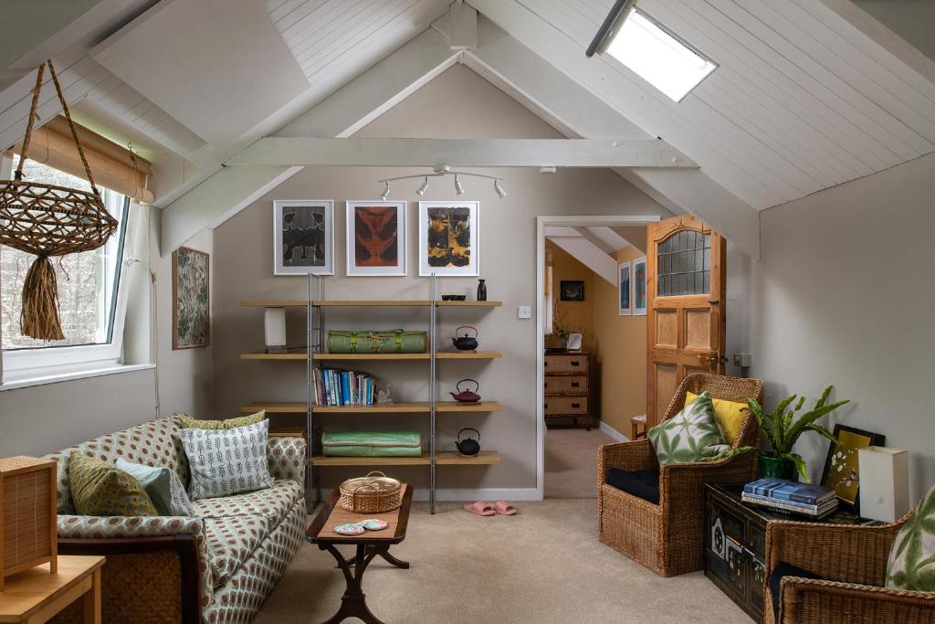 a living room with two couches and a book shelf at Zen Den Cornwall in Boscastle