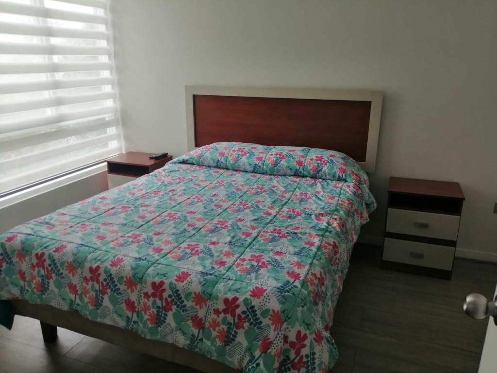 a bedroom with a bed with a quilt on it at DEPARTAMENTO EL OASIS in La Serena