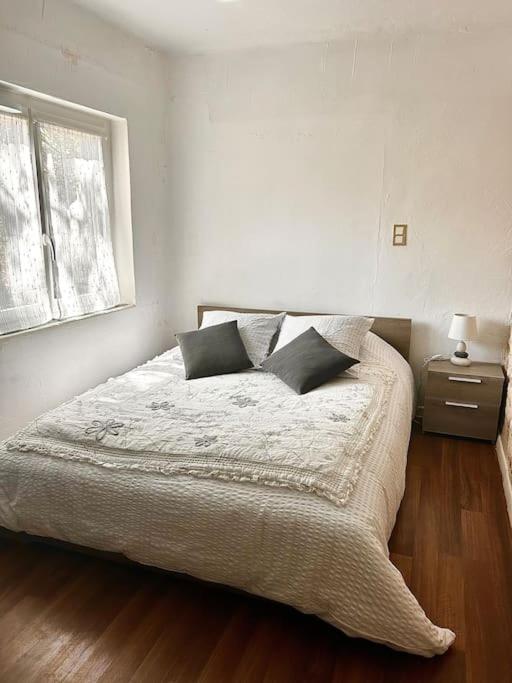 - une chambre avec un lit avec deux oreillers et une fenêtre dans l'établissement Ancienne petite bastide provençale, à Sanary-sur-Mer