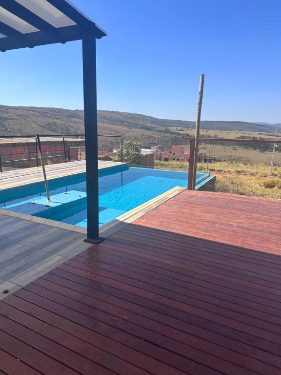 a swimming pool on top of a wooden deck at Casa com piscina Capitólio in Capitólio