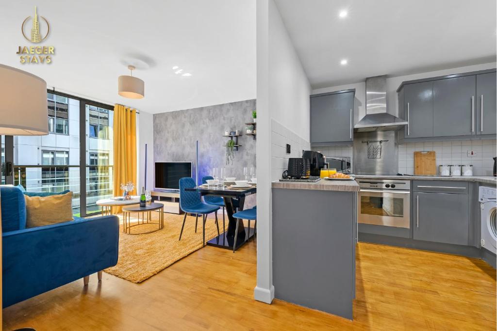 a kitchen and living room with a blue couch at 2 Bedroom Greek Street Apartment - Sleeps 6 in Leeds