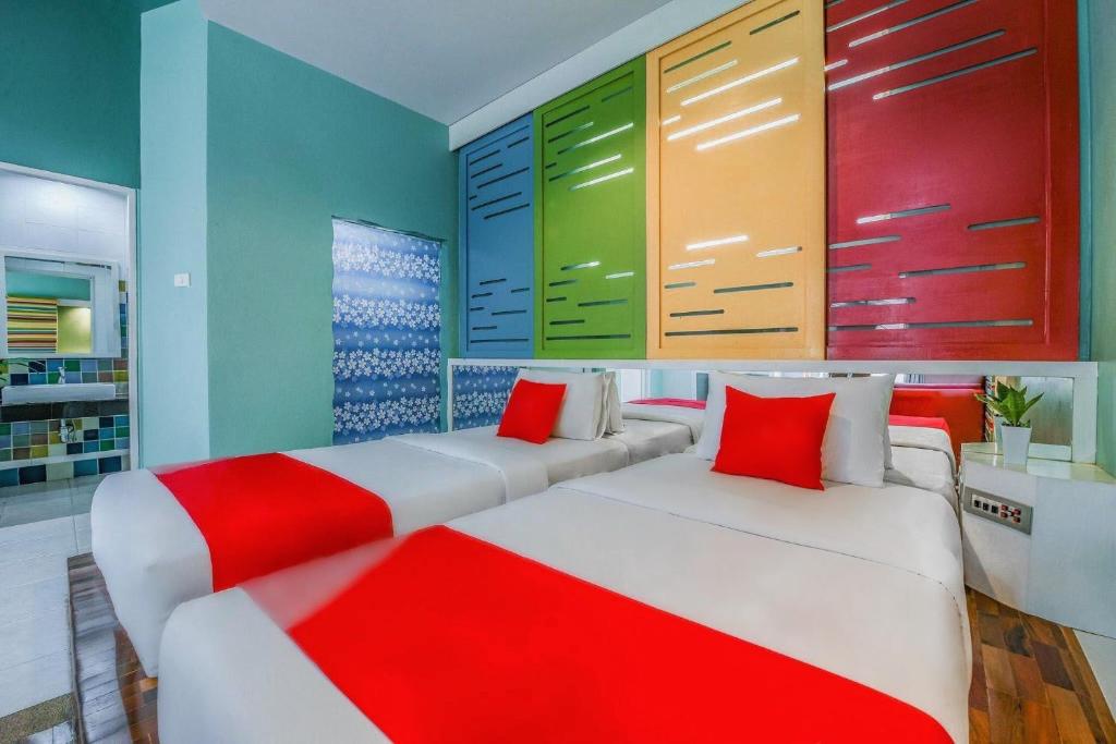 two beds in a room with blue and red at Suan Palm Garden View in Rayong