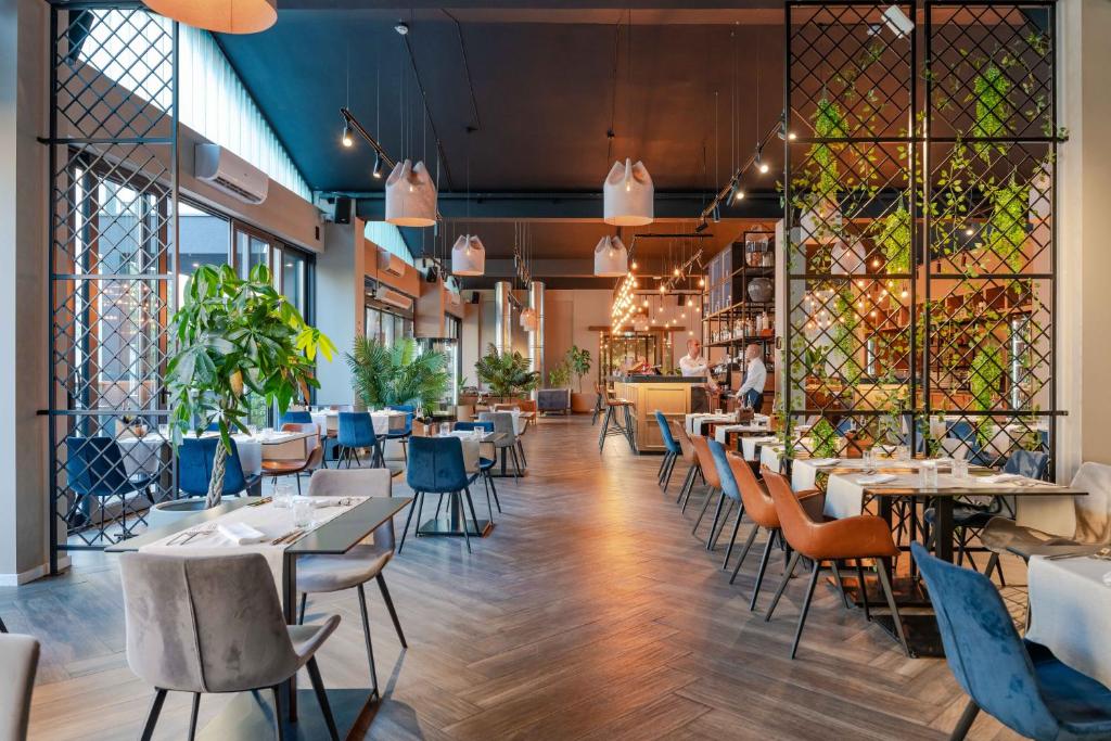 ザダルにあるHotel A'mareのテーブルと椅子と窓のあるダイニングルーム