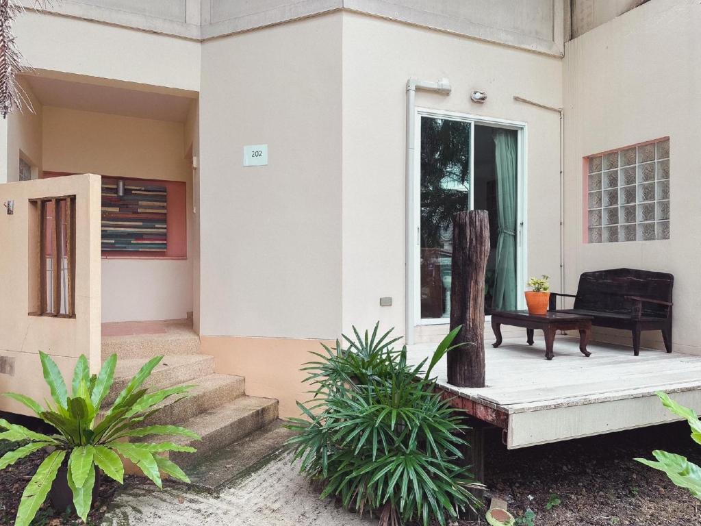 a front porch of a house with a black chair at Suan Palm Garden View in Rayong