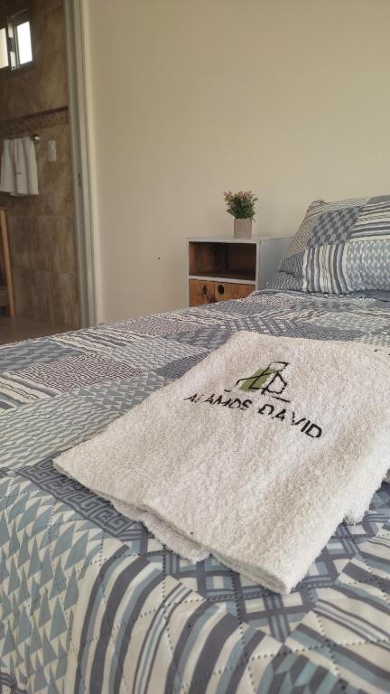 Una cama con una manta encima. en Alamos David, en Villaguay