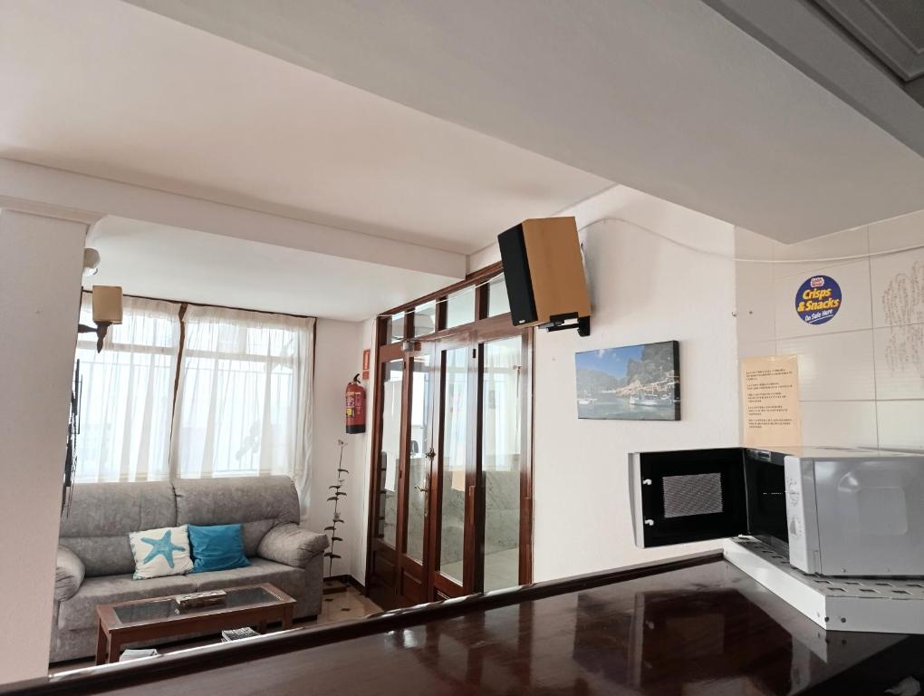 a living room with a couch and a microwave at Hostal Horizonte in San Antonio
