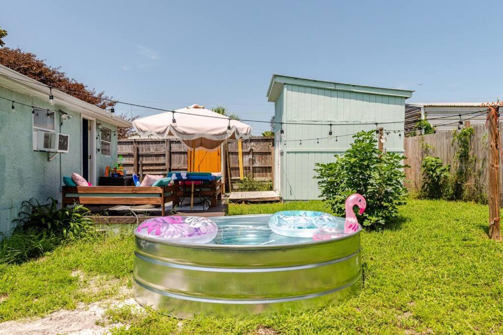 a pool of water with two pink flamingos in a yard at Fun-filled home with pool, near beach, pets welcome! in Panama City Beach