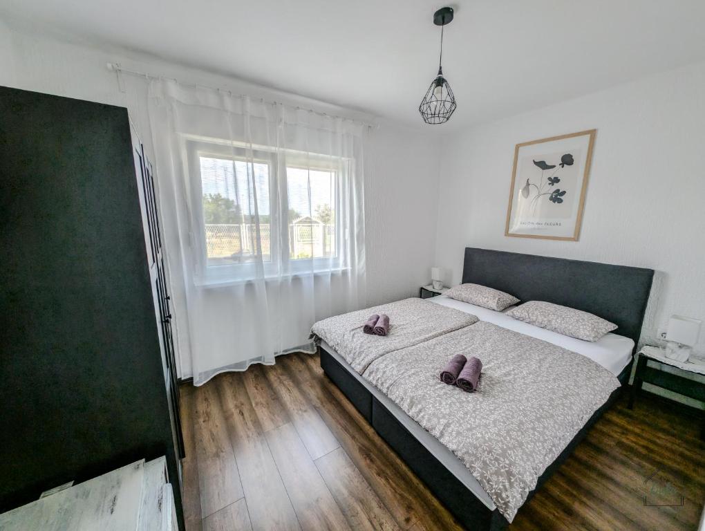 a bedroom with a bed with two purple pillows on it at Kuća za odmor Fjaka in Sotin