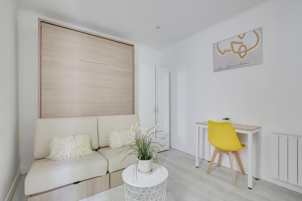 - un salon avec un canapé blanc et un fauteuil jaune dans l'établissement Studio chic aux portes de Paris, à Colombes