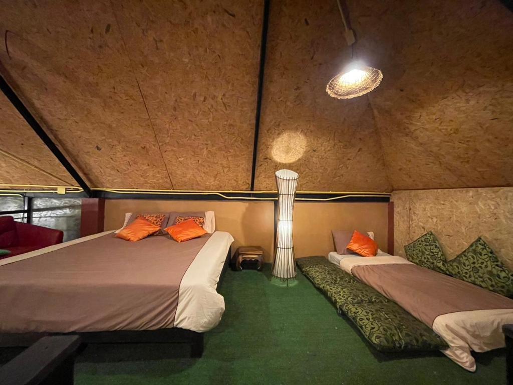 une chambre avec deux lits dans une tente dans l'établissement Baibon1 Boutique House Thalang Phuket, à Ban Na Nai