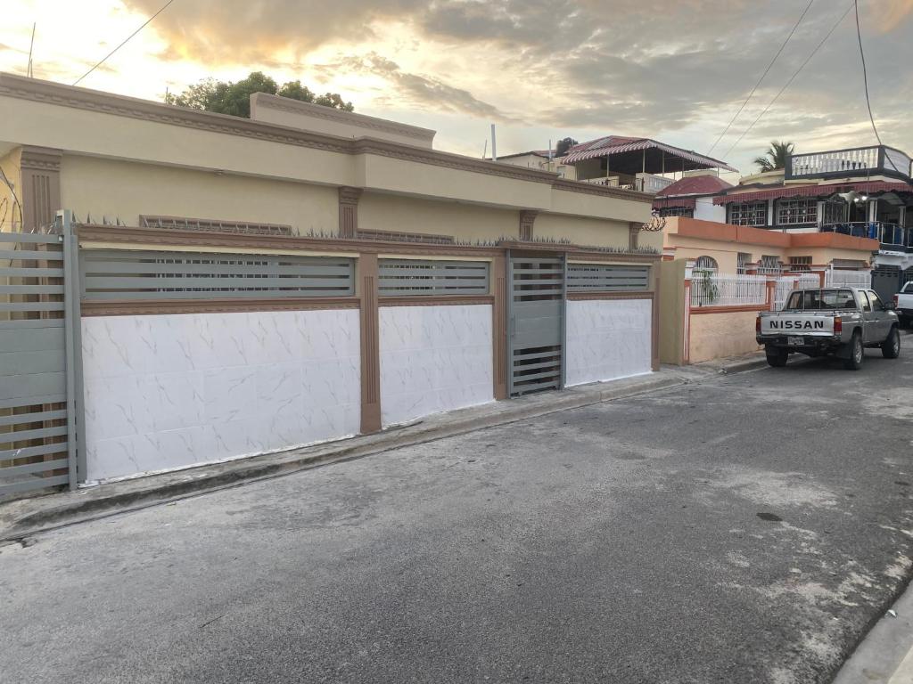 Un edificio con dos puertas de garaje y un camión estacionado en frente. en La Castillada House, en Santa Cruz de Barahona