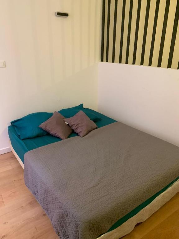 un lit avec deux oreillers dessus dans une chambre dans l'établissement Maison colonnes 4 personnes, à Bastia