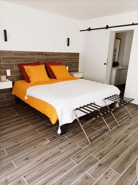 une chambre avec un lit et un parquet dans l'établissement L' Har & Lam, à Leuilly-sous-Coucy