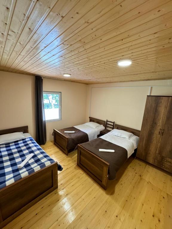 2 camas en una habitación con suelo y techo de madera en Second home in Mestia, en Mestia