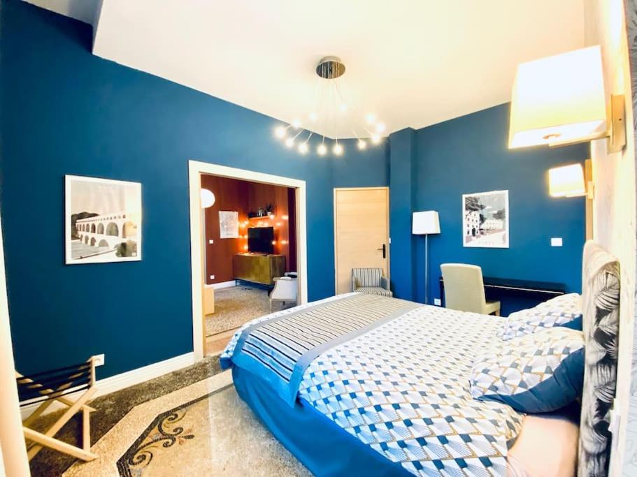 - une chambre avec des murs bleus et un lit dans l'établissement La suite 2 pièces lit queen size entrée privée, à Nîmes