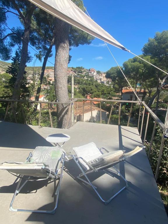 two chairs and an umbrella on a patio at Villa Nicole avec Spa professionnel in Carry-le-Rouet