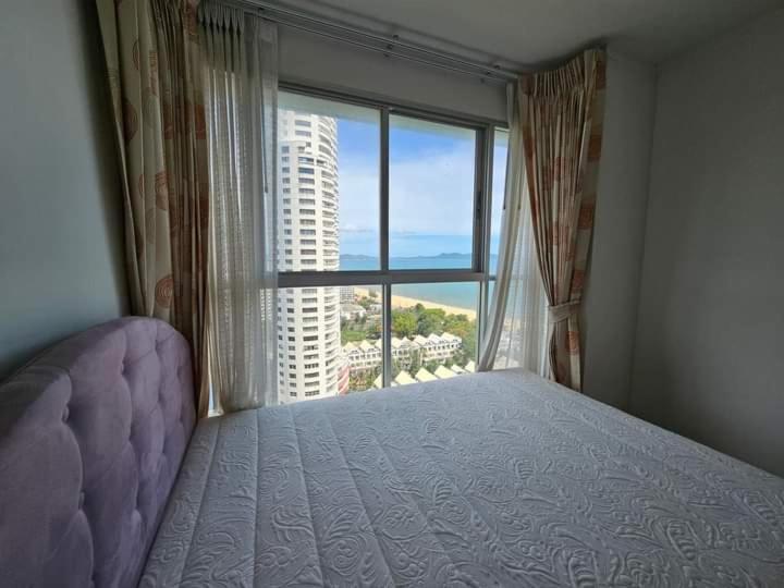 a bedroom with a bed and a large window at jomtien pattaya condo seaview room premium 33sqm in Jomtien Beach