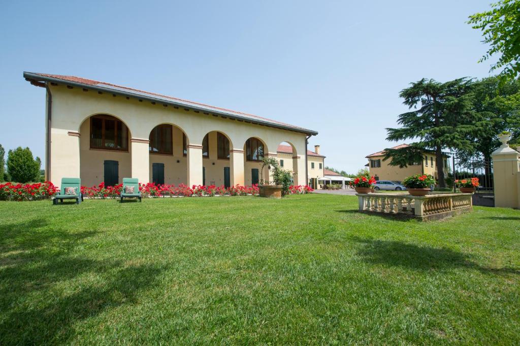 un bâtiment avec une grande cour avec de l'herbe et des fleurs dans l'établissement Hotel Venice Resort Airport, à Tessera