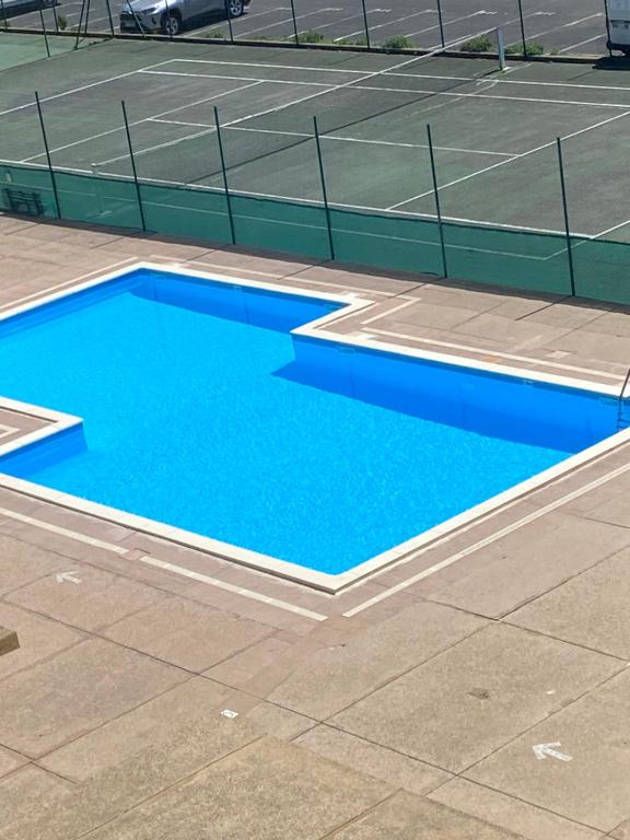 - un court de tennis avec une piscine bleue dans l'établissement Capfamille, au Cap d'Agde