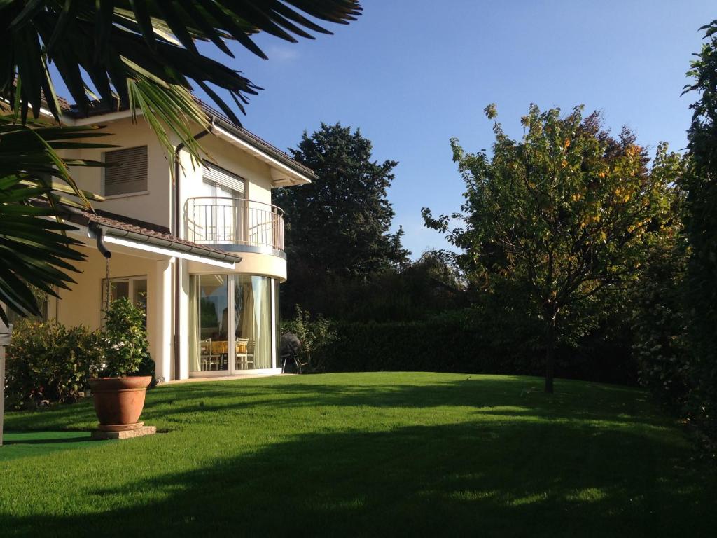 ein Haus mit einem grünen Garten mit einem Baum in der Unterkunft Chambre D'Hôtes Wellingtonia in Mont-sur-Rolle