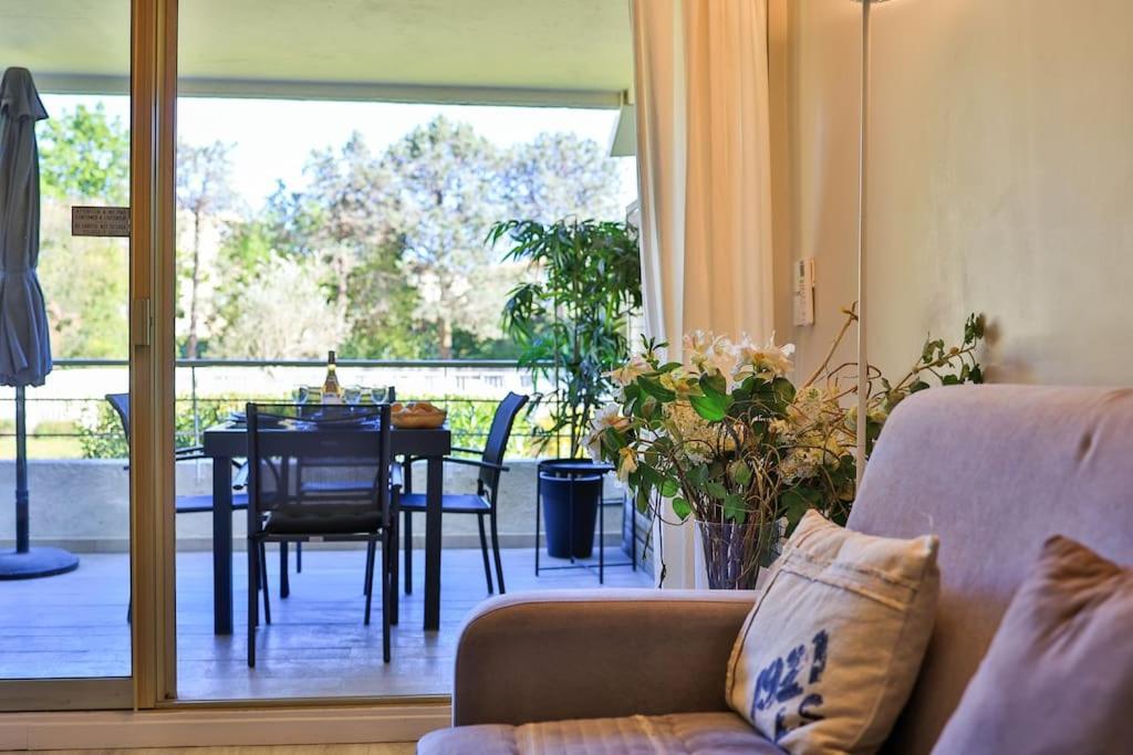 - un salon avec un canapé et une table à manger dans l'établissement 2 pièces, piscine et parking centre de St Tropez, à Saint-Tropez