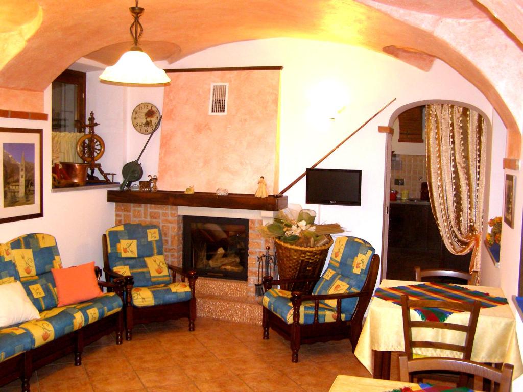 sala de estar con sillas y chimenea en L'Antico Borgo Rooms Rental, en Caprie
