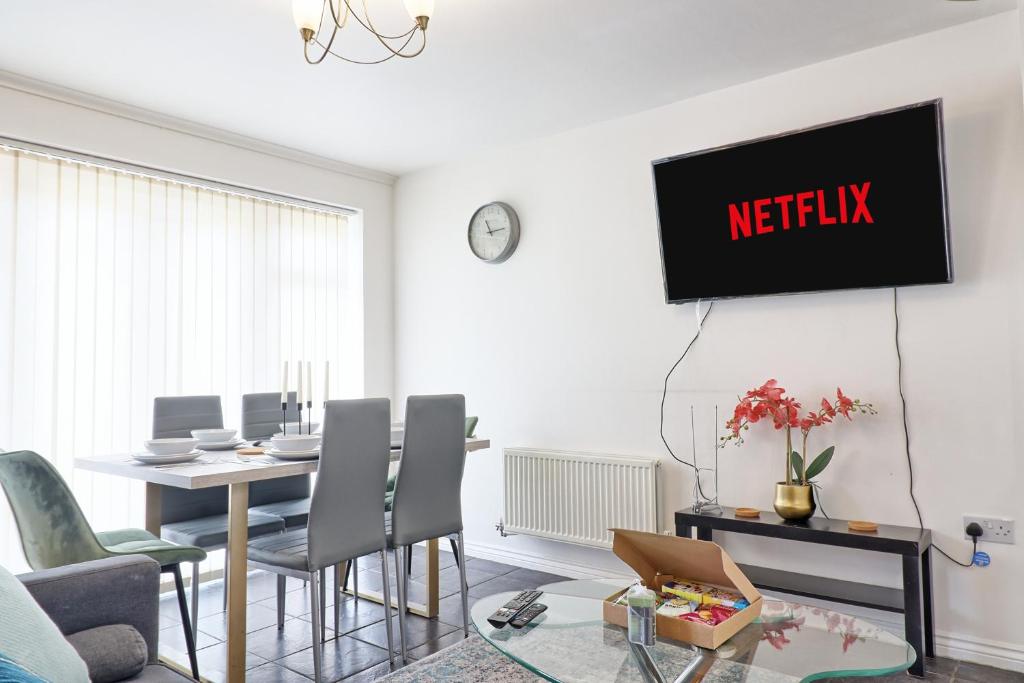 a living room with a table and a tv on the wall at ESSEX Basildon 4 bedroom house 2 half bath in Basildon
